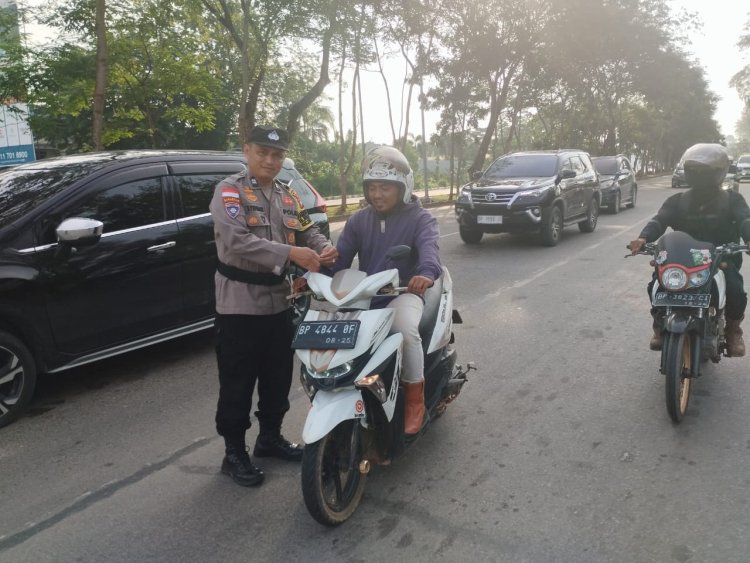 POLSEK SEKUPANG BAGIKAN 200 BENDERA MERAH PUTIH KEPADA PENGENDARA DI LAMPU MERAH HILLTOP, DALAM RANGKA MENYAMBUT HUT RI KE-80