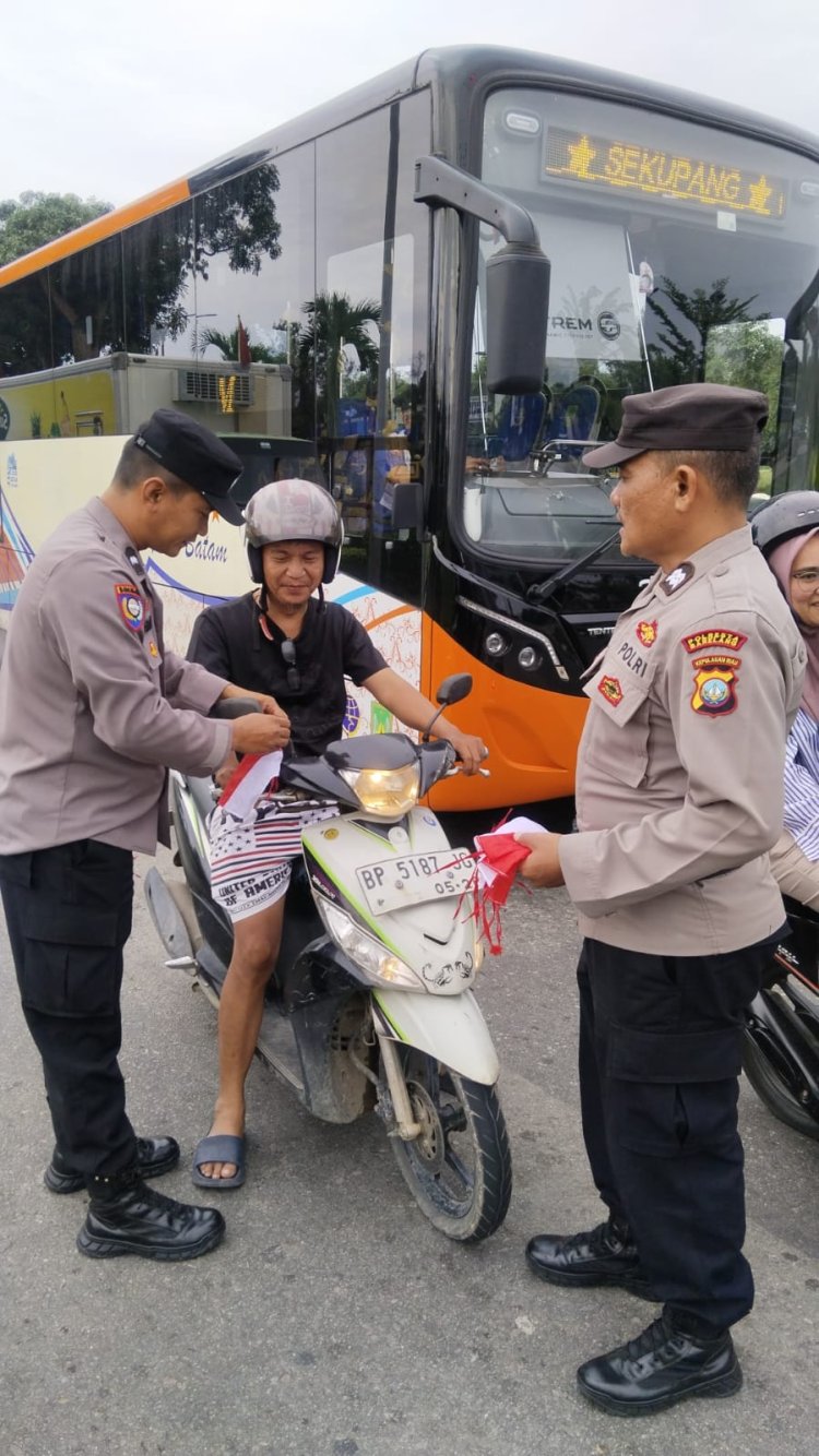 POLSEK SEKUPANG BAGIKAN 150 BENDERA MERAH PUTIH KEPADA PENGGUNA JALAN DALAM RANGKA HUT RI KE-80