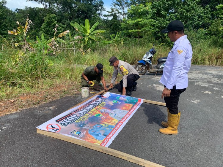 Cegah Karhutla, Bhabinkamtibmas Desa Lanjut Bersama Pemdes Pasang Spanduk Himbauan